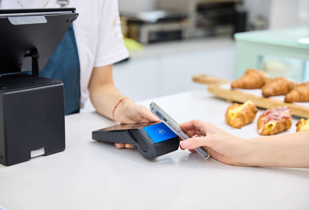 istock Close-up of an unrecognisable customer paying the bill via smartphone using NFC technology in a coffee shop 2026304426
