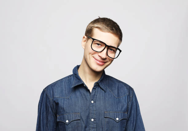 young handsome man wear eyeglasses looking at camera on grey background