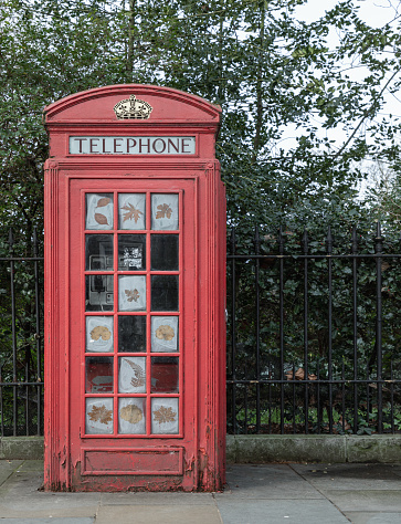 London, UK - Feb 15, 2024 - Traditional red telephone cabine in London city. Classic red british phone box booth, Space for text, Selective focus.