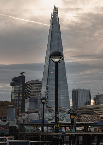 London, UK - Feb 15, 2024 - View of The Shard skyscraper, The tallest building with HMS Belfast warship museum on River Thames in front of it. Space for text, Selective focus.