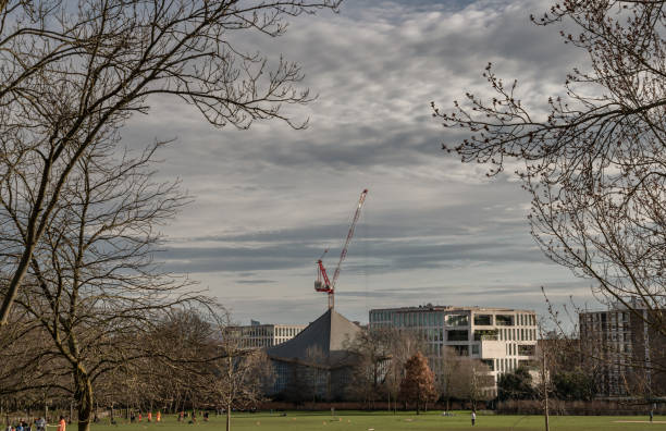Construction work with crane and Hyperbolic-paraboloid roof of The design museum with sky background.