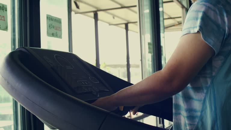 Asian plump woman walks and exercises on a treadmill inside the gym, Burn fat to lose weight