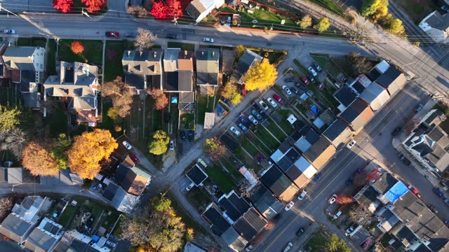 Urban USA city during autumn. Aerial top down view of roads, rowhouses and colorful fall trees. High diagonal drone shot.