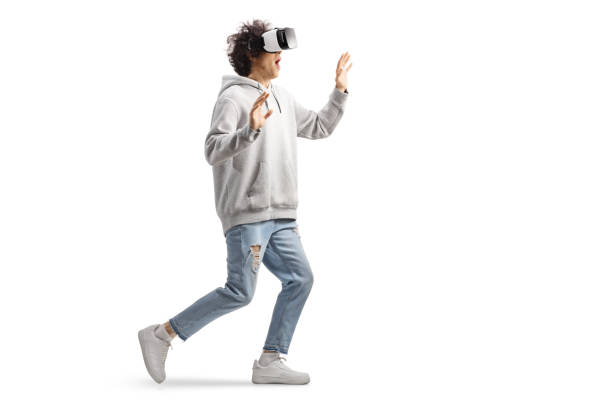 istock Young casual man with a VR headset walking and touching with hands 2026500982