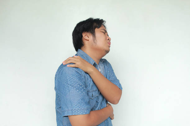 istock Asian man holds his shoulder with a pained expression. 2026523539