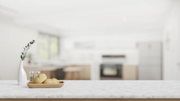 istock A white marble tabletop with empty space, a bread basket, and decor in a modern white kitchen. 2026602803