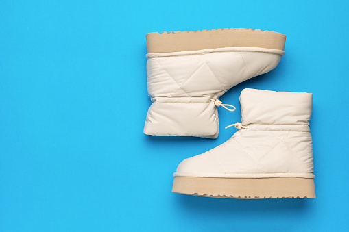 A pair of warm women's high-soled boots on a blue background. Women's shoes for cold weather.