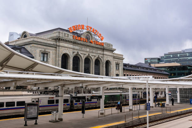 Denver, Colorado - March 24, 2023 - Union Station under cloudy skies on a winter afternoon with a train in the station and surrounding skyline.
