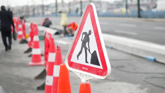 Man walking by traffic sign on street with construction site
