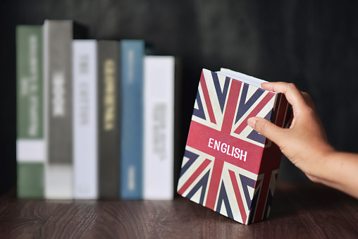 English book with hand selected from the bookshelf. Learning English fluently are advantages such as can connect to the new people, new bussiness, make more money, and immigration benefits.