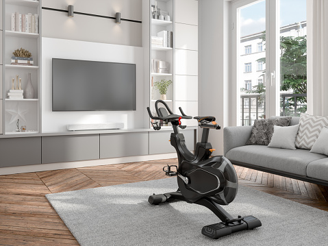 Living Room Interior With Exercise Bike, Sofa And Television Set. Exercising On Tv At Home