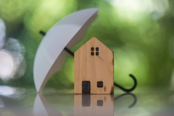 istock Wood house sheltered by umbrella with blur nature background. Insurance coverage concept. 2026795830