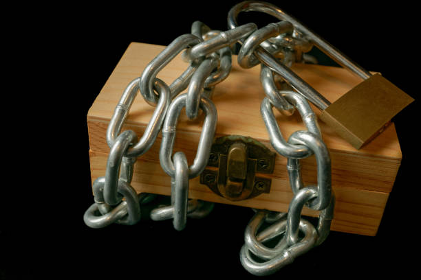 wooden box tied with a chain and a padlock isolated on black background and copy space