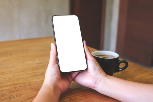 istock Mockup image of a woman holding mobile phone with blank desktop screen 2026813467