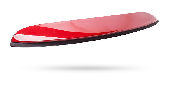 Red sports style spoiler for installation on the trunk lid on a white isolated background in a photo studio in a car repair shop for sale at an auto-parsing.