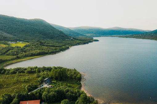High-angle drone photo of beautiful mountain lake surrounded by fresh green peaks by the fjord in Western Noway