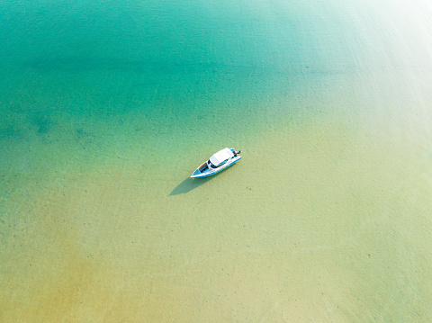 Aerial drone view of beautiful beach with turquoise sea water and speed boat of Gulf of Thailand. Kood island, Thailand.