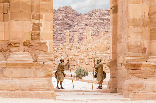 Wadi Musa, Jordan, October 05, 2023 : Two Bedouins dressed in military uniform of ancient Nabateans guard the passage between the columns in Nabatean Kingdom of Petra in Wadi Musa city in Jordan