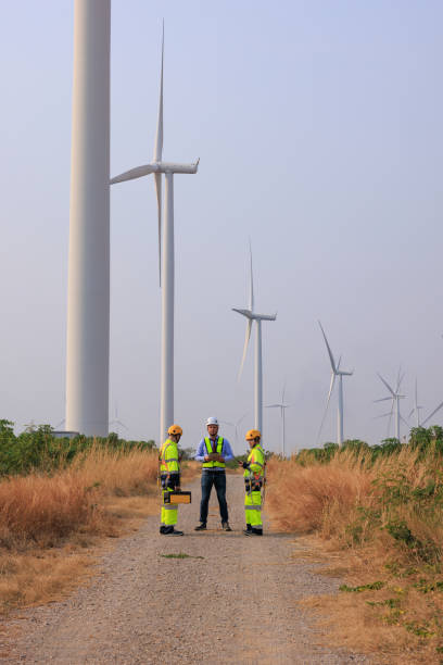istock Engineer team hold equipment and tablet standing to talk planing project install wind turbines in the agricultural area. renewable energy installation project for the future world 2026882736