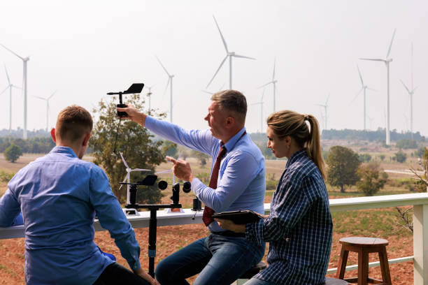 istock Engineer team hold equipment and tablet sitting to meeting planing project install wind turbines in the agricultural area. 2026886371
