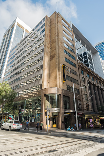 Sydney, NSW, Australia, February 17th 2024. A general view of a Commonwealth Bank on a city street corner with people waiting at a stoplight.