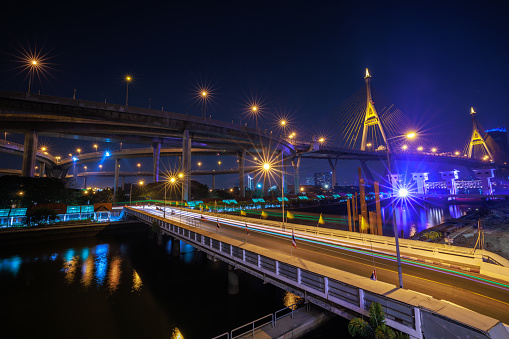Night scene shot and over starlight effect, Bhumibol bridge and reflection of water. bangkok thailand, wide angle cityscape at night transport concept,