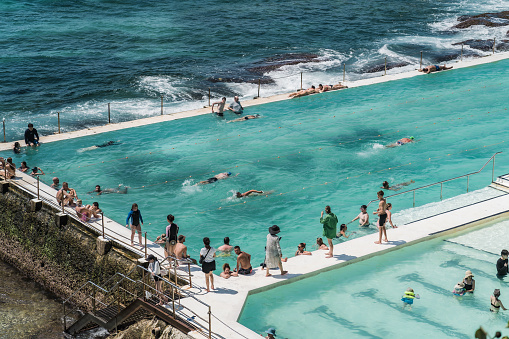 Sydney, NSW, Australia, February 18th 2024. Bondi Icebergs Swimming Club Pool, with swimmers and sunbathers against the backdrop of the Tasman Sea.