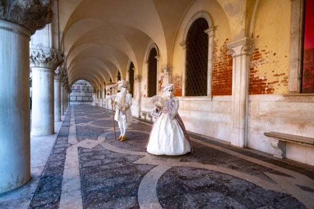Venice, VE, Italy - February 13, 2024: man and woman with huge imaginative hats during the carnival by the sea