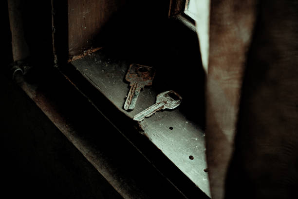 A rusty key sits in a wooden window frame