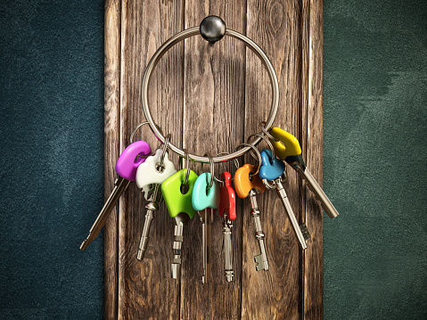 Bunch of keys with various color choices hanging on the wooden wall. Choice concept.