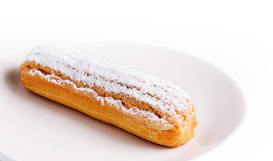 Delicious french dessert Eclair on plate