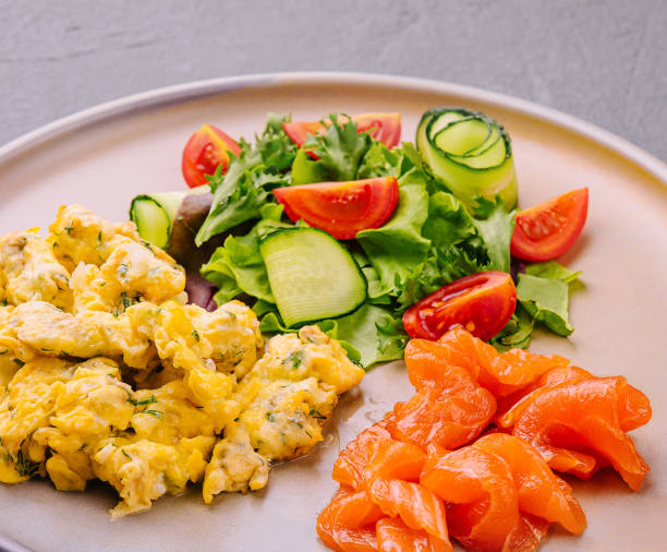 istock Scrambled eggs with salmon and tomato and cucumber salad 2027034852