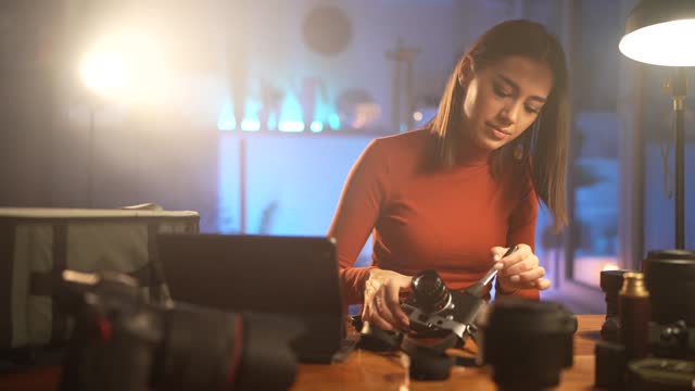 Woman cleaning photographic equipment at home