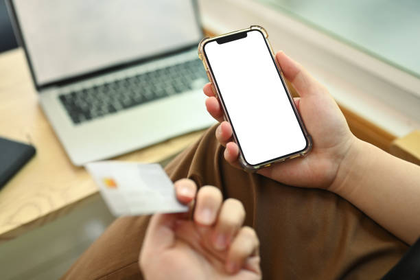 istock Man holding smartphone with blank empty screen and credit card. Closeup view 2027076719