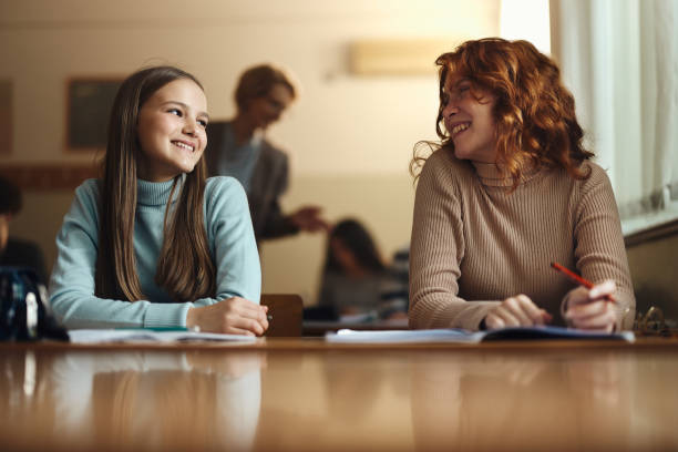 istock Happy female students talking on a class at high school. 2027078303