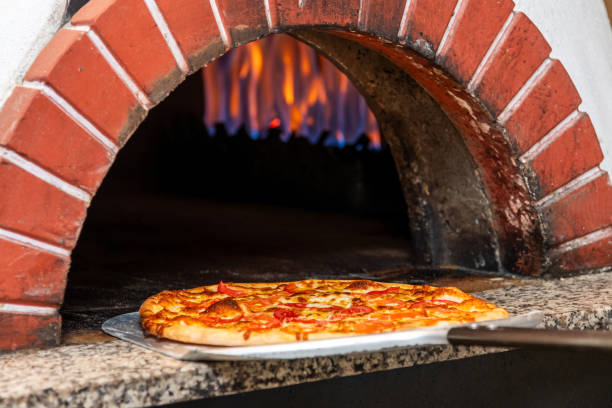 istock Mixed pizza fresh from the pizza oven with flames visible in the background 2027088333