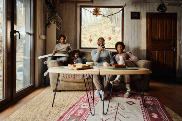 istock Happy black family enjoying while watching TV at home. 2027101036