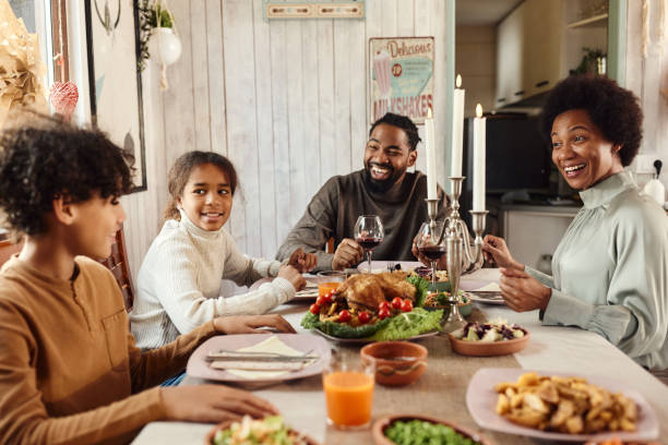 istock Happy black family talking during lunch at dining table. 2027102108