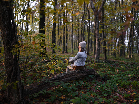 Back view of carefree woman day dreaming while relaxing in autumn day at the forest. Photographed in medium format.