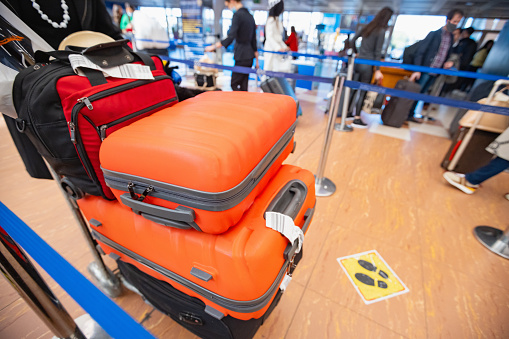 Pushing stacked suitcases on luggage cart at the airport arrival departure area