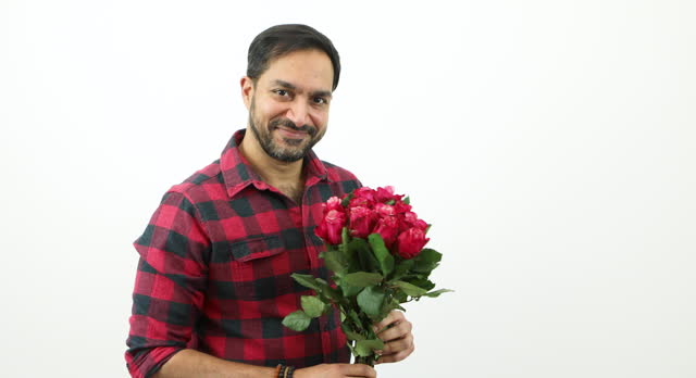 Handsome man holding a bunch of red roses