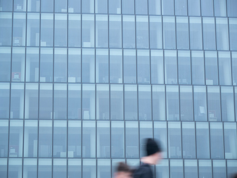 office corporate building with motion blurred young person with cap passing