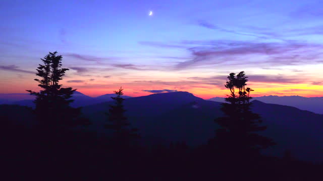 Crescent Moon Rising Over Sunset Mountains