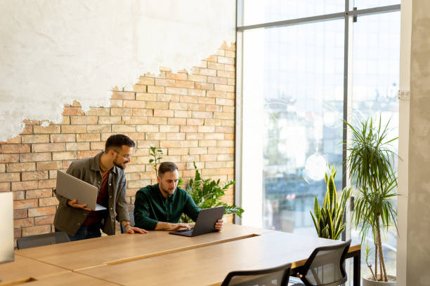 istock Collaboration in Motion, Professionals Working Together in a Modern Brick-Walled Office 2027162721