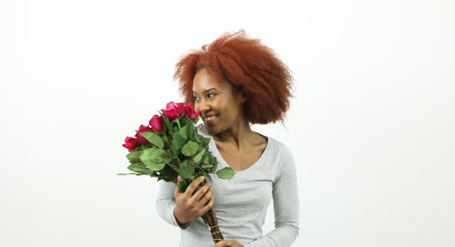 Attractive young woman holding a bunch of red roses