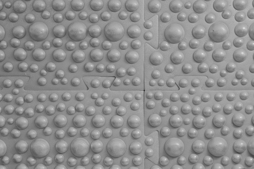 Close-up of a massage mat with hemispherical working ridges. Gray surface for painting in any color. Background. Texture.