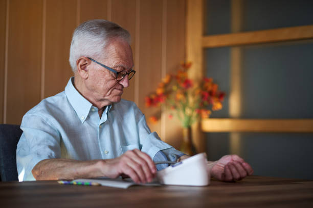 istock A elder man taking his blood pressure at home. 2027192438