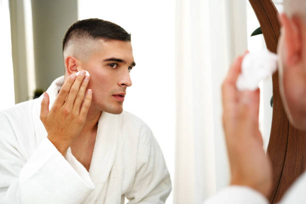 istock Reflection of a young man shaving in bathroom mirror close up 2027192885