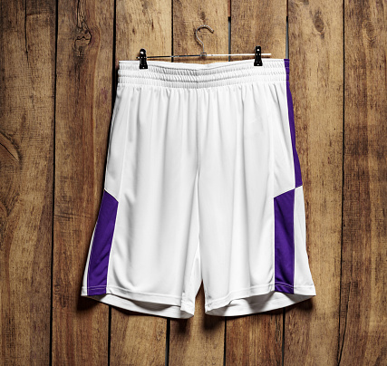 Basketball uniform shorts hanging against wooden background