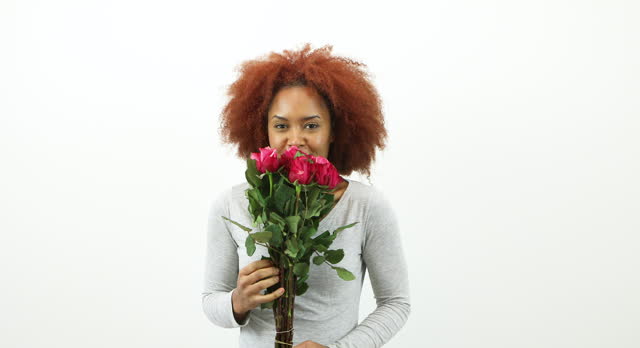Attractive young woman holding a bunch of red roses